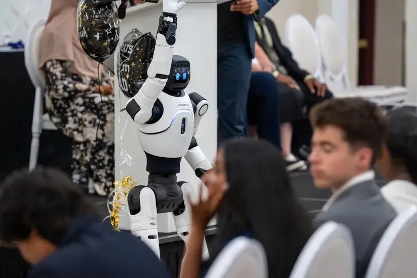 A robot is performing in a middle school graduation.